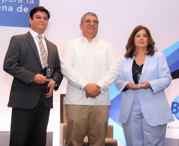 En el centro, el presidente de BASC Dominicana, Horario Lomba, entrega reconocimientos a la presidenta de Dominican Watchman, Lucile Houellemont y al director de negocios de esa empresa de seguridad, Hideki Satake.