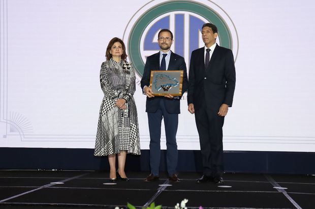 Raquel Peña y Karel Castillo entregan reconocimiento del Grupo SID a Roberto Bonetti.