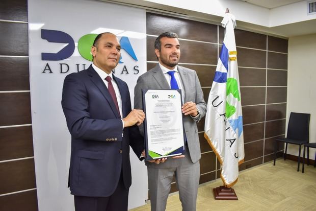 El director de Aduanas, Enrique Ramírez, entrega la certificación OEA a Jean Carlos Espaillat, ejecutivo de Espalsa.