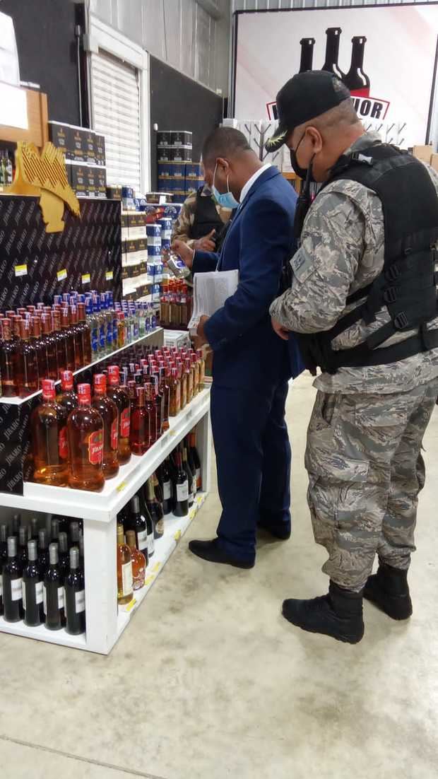Autoridades en la confiscación de bebidas alcohólicas. 