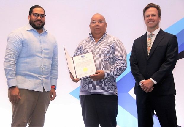 El agregado comercial para la región del Caribe de la Embajada de los Estados Unidos, Bryan Goldfinger, entrega una certificación de seguridad BASC a los ejecutivos de la empresa Servicio de Vigilancia Corporativo.