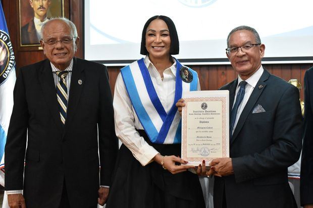 La voleibolista Milagros Cabral recibe la certificación de miembro de honor del Instituto Duartiano, de manos de su presidente y vicepresidente, los doctores Wilson Gómez Ramírez y Julio Manuel Rodríguez Grullón.