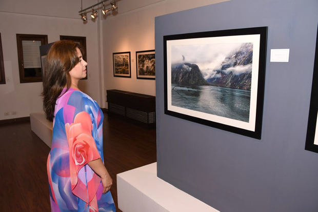 Liz Acevedo, disfrutando de la exposición de Fotografía “Windows To Down Under”, de Mary Frances Attias.