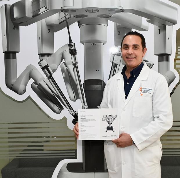 Doctor Pablo Mateo, acompañado de la consola robótica y su certificación.