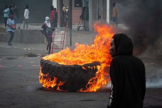 Personas encienden neumáticos mientras protestan en Puerto Príncipe (Haití). La tensión aumenta hora a hora en Haití, donde este viernes se sucedieron los saqueos y la violencia, y miles de personas se manifestaron para exigir la salida del poder del primer ministro, Ariel Henry.