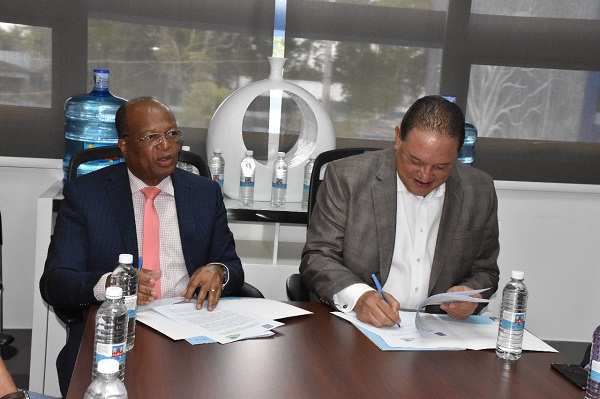 Héctor Mojica y Alejando Montas, durante firma de convenio entre OMSA y CAASD