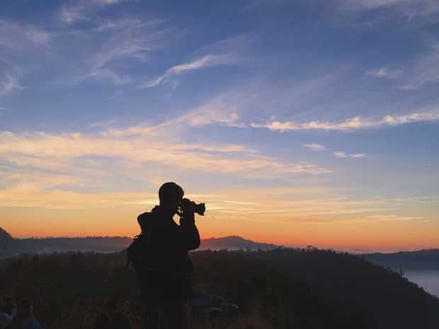 Silueta de la persona que habla de la foto durante la puesta del sol.