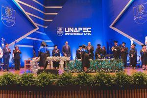 Momento en que el rector de Unapec entrega el título a una graduanda.