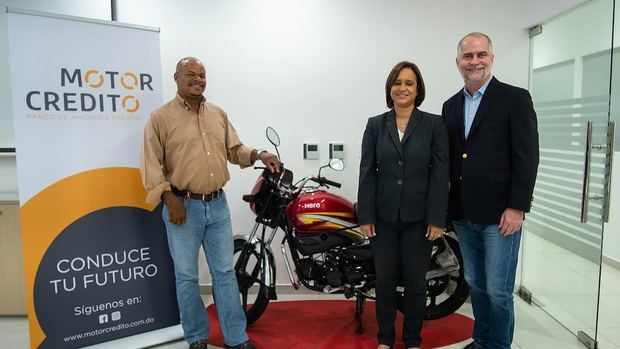 Analista financiero Alejandro Fernández W. y Benahuare Pichardo junto a motoconchista en la charla.