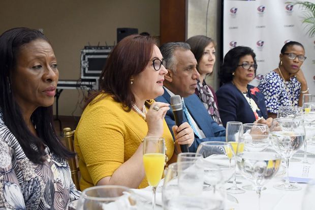 Ministra de la Mujer, Janet Camilo, en la mesa principal mientras da su discurso.