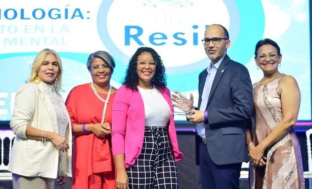 Nancy Alvarado, Emma Guzmán, Adriana Mirabal y Sandra Fernández entrega una placa de reconocimiento a Romer Concepción.