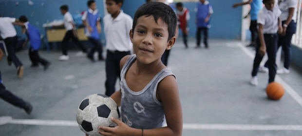 Un niño juega al fútbol en la escuela El Carmen en Petare, Caracas, Venezuela.