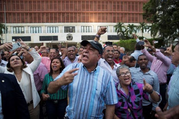 Manifestantes participan durante una protesta en contra de una posible reforma a la Constitución que permitirá la reelección del Presidente Danilo Medina, el enfrentamiento tuvo lugar frente al Congreso Nacional de la República Dominicana.