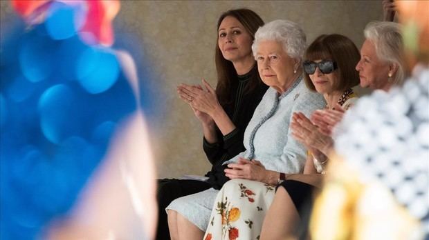 Isabel II sentada al lado de Anne Wintour durante el desfile.