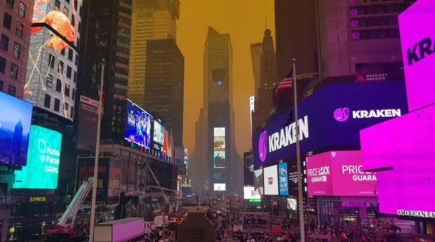 Cielo color naranja debido al humo resultante de los incendios forestales canadienses visto desde la zona de Times Square de Nueva York.