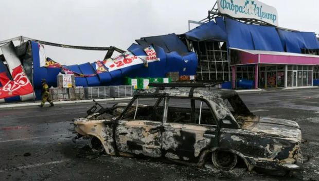 Un automóvil calcinado frente a un centro comercial destruido por un misil, el 25 de diciembre de 2023 en Horlivka, en la zona al este de Ucrania bajo control ruso.