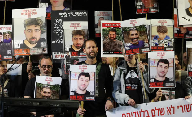 Simpatizantes y familiares sostienen fotografías de rehenes retenidos por Hamás en Gaza mientras participan en una manifestación, en Tel Aviv (Israel).