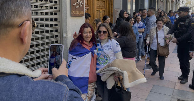 Votantes salvadoreños hacen cola en la puerta del consulado del país en Madrid para ejercer su derecho al voto en el exterior.