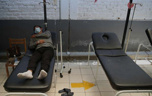 Un hombre con dengue yace en una camilla en el establecimiento de salud de Catacaos, departamento de Piura (Perú).