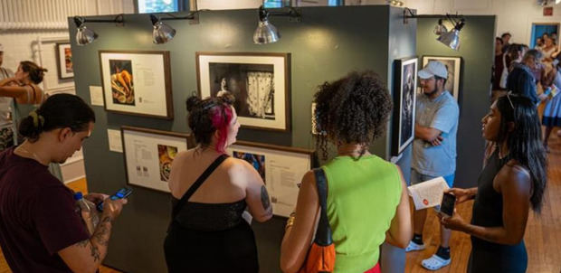 Personas observan una exposición de fotografía.