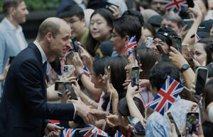 El Príncipe Guillermo de Gran Bretaña, Príncipe de Gales, saluda a la multitud reunida frente al Rain Vortex, en Singapur.