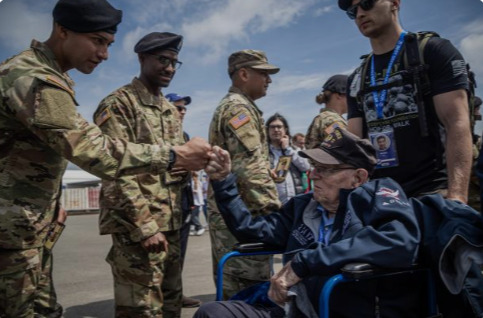 Un veterano estadounidense de la Segunda Guerra Mundial choca su puño contra el de un soldado de su país en Deauville.