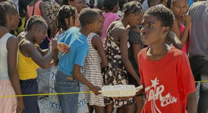 Niños haitianos hacen cola para recibir una comida caliente y agua distribuidas por el PMA en Puerto Príncipe.