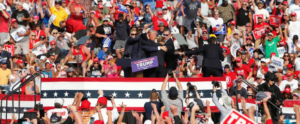 Donald Trump sacado del escenario por el Servicio Secreto tras un atentado en su contra durante un mitin de campaña el sábado, en Pensilvania (Estados Unidos).