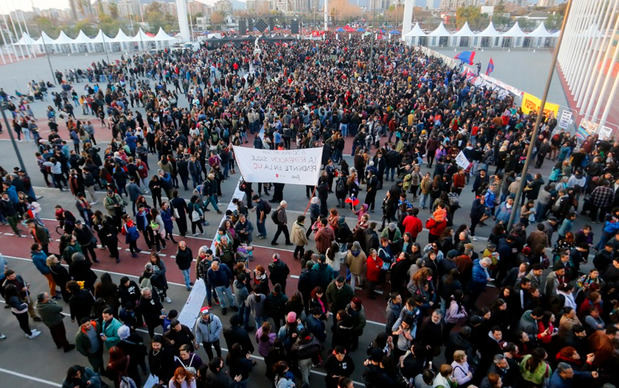 Asistentes al acto en memoria de los detenidos desaparecidos durante la dictadura de Augusto Pinochet en el Estadio Nacional en Santiago (Chile).