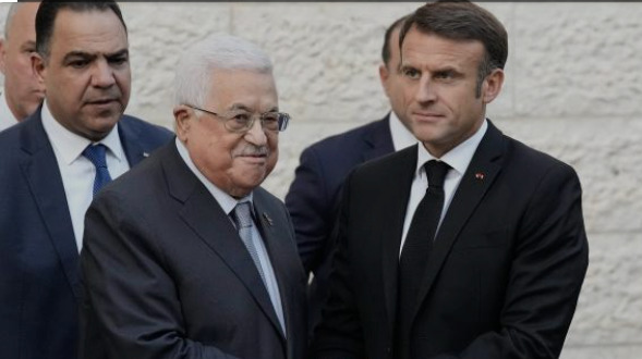 El presidente de Francia, Emmanuel Macron, saluda al presidente palestino, Mahmud Abás.
