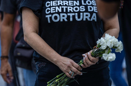 Mujer sostiene flores durante la gran vigilia nacional por los presos políticos convocada por la oposición en la plaza Los Palos Grandes, en Caracas (Venezuela). 