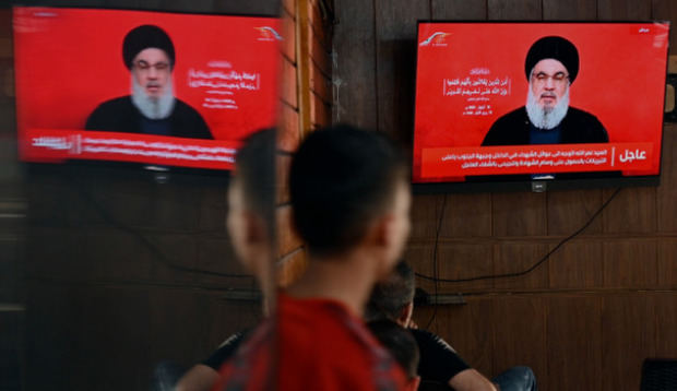 La gente observa al secretario general de Hezbolá, Hassan Nasrallah, pronunciando un discurso televisado en una cafetería en el suburbio sur de Beirut, Líbano.
