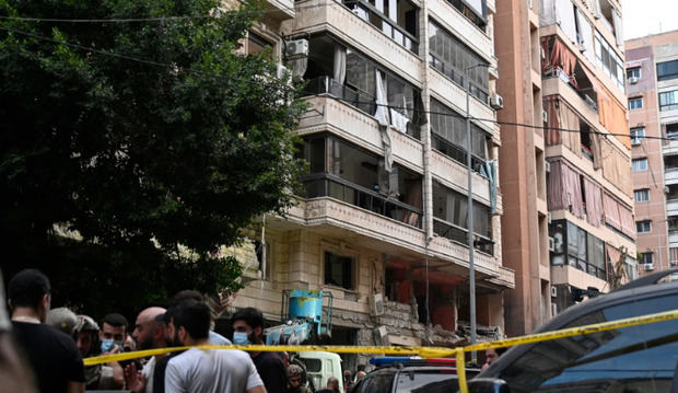 Varias personas se reúnen frente a un edificio dañado tras un ataque militar israelí, en Beirut (Líbano).