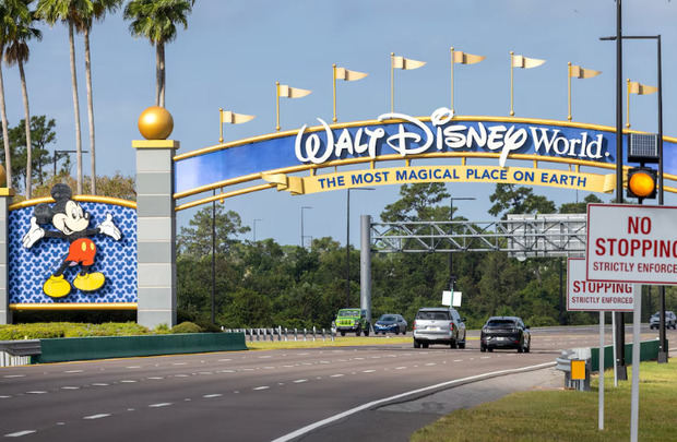 Fotografía de automóviles que pasan bajo una de las puertas de acceso a Walt Disney World en Kissimmee, Florida, Estados Unidos.
