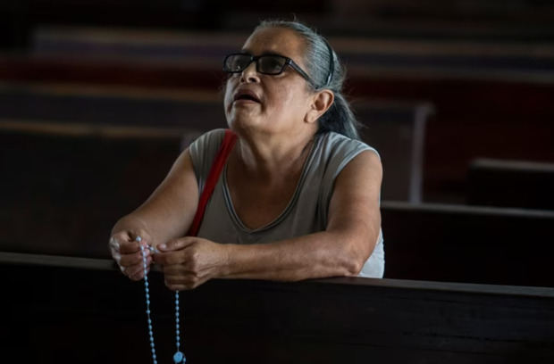Una mujer reza en una iglesia católica en Nicaragua del país centroamericano se ha convertido también en foco de represión por parte del gobierno.