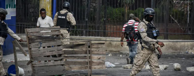 Policías vigilan a manifestantes que participan de una gran protesta antigubernamental en Puerto Príncipe (Haití). 