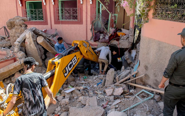 Varias personas tratan de retirar los escombros en un edificio dañado en Marrakesh.