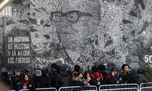Un grupo de personas frente a una imagen del derrocado presidente de Chile Salvador Allende, en un acto conmemorativo del 50 aniversario del Golpe de Estado de Pinochet.