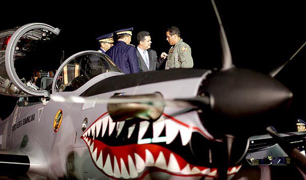 El ex presidente de República Dominicana, Leonel Fernández (2da desde la derecha), habla con oficiales militares después de revisar un avión de combate, conocido como Super Tucano, en una base militar en Santo Domingo el 10 de diciembre de 2009. Fernández asistió a una ceremonia militar para conmemorar la llegada de dos de ocho aviones de combate comprados a Brasil para combatir el narcotráfico en la isla caribeña, informaron medios locales. 