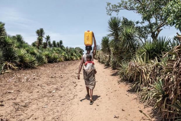 Claudine y su hijo regresan a su casa en Mantara, Madagascar, después de caminar 14 km para recoger agua.