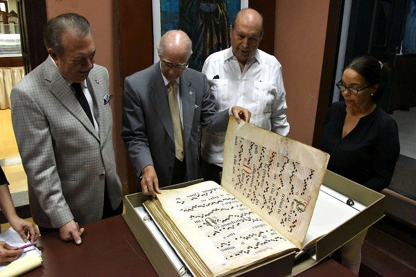 El ministro Eduardo Selman observa la obra “El Himnario Antiguo”, con presentación forrada en piel de becerro.