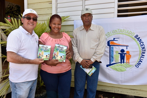 1.	Luis Martin Gómez y Onofre Rojas entregan ejemplares del cuento a Dulce María Peralta, directora de la Escuela Pepe Pérez, de Yamasá, Monte Plata. 