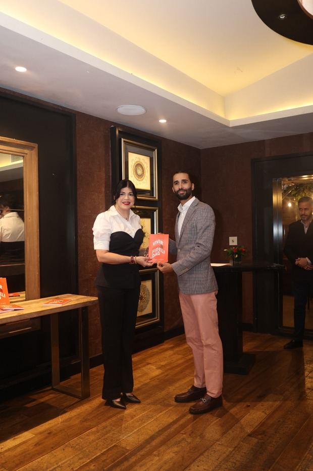 Ana Simó entrega un ejemplar del libro a Ariel Báez, representante de la Facultad de Humanidades de Unicaribe.