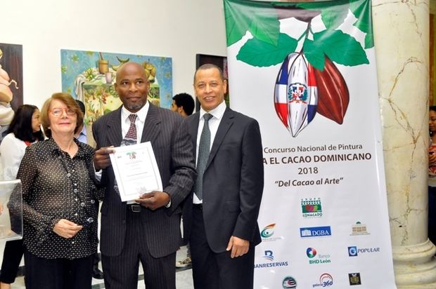 Pancracio Almonte, tercer lugar recibe el certificado de las manos de Marianne de Tolentino y el director ejecutivo de Conacado Isidro de la Rosa..