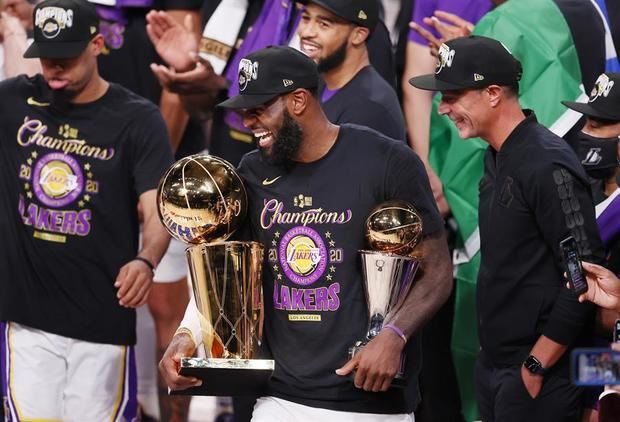 El jugador de los Lakers de Los Ángeles LeBron James (c) festeja con el trofeo Larry O'Brien que ganó su equipo ante los Heat de Miami en el complejo deportivo ESPN Wide World, este 11 de octubre de 2020.