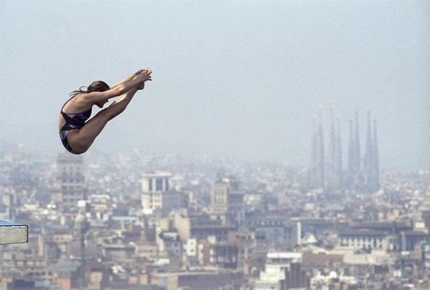 Una saltadora de trampolín, durante la prueba de 10 metros, en los Juegos Olímpicos de Barcelona 1992. Al fondo, la ciudad condal y el templo de la Sagrada Familia.