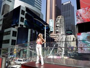 Una transeúnte disfruta de la nueva rueda de Chicago instalada en Times Square, en Nueva York, EE.UU.