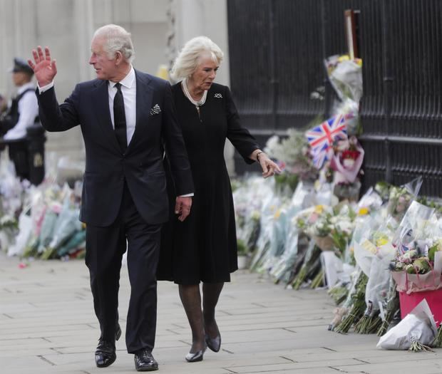 El rey Carlos III y Camilla, la reina consorte, saludan a los londinenses a su llegada al Palacio de Buckingham, donde las personas depositaron tributos florales en honor de la reina Isabel II este 9 de septiembre.
