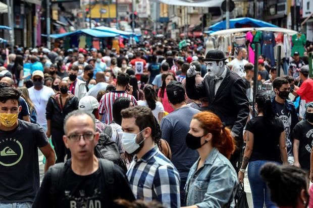 Transeúntes caminan por una vía comercial en el centro de Sao Paulo, Brasil.