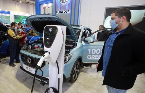 Un visitante observa las características de un coche electrico en una feria de automóviles en El Cairo.